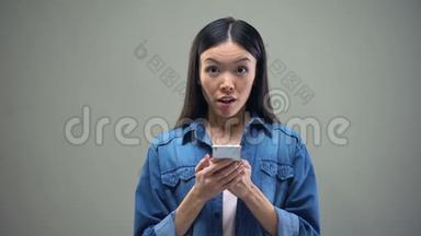 女人在智能手机上阅读信息，变得非常快乐，彩票中奖